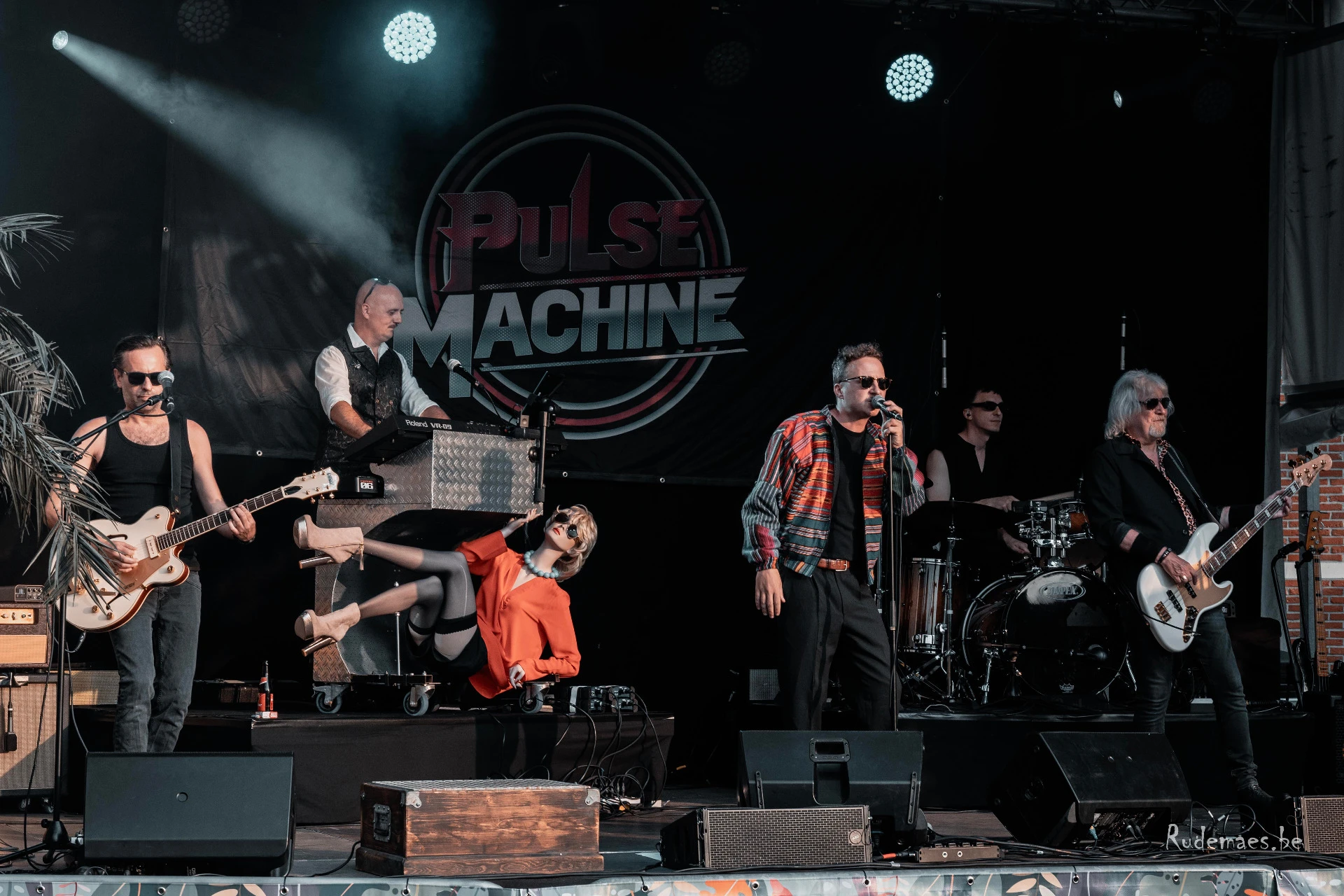 De volledige band op het podium met Pulse Machine logo