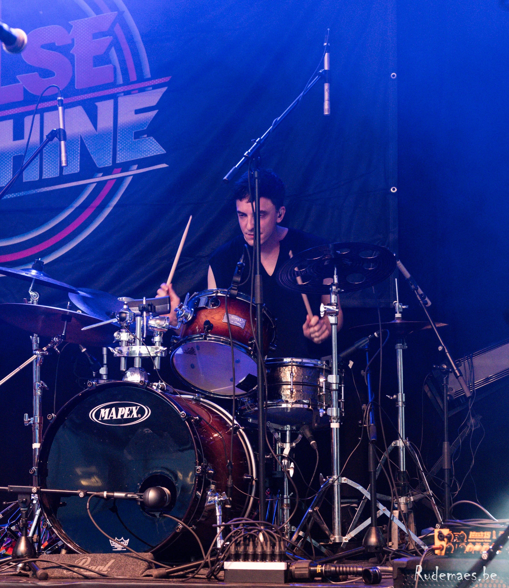 Joris achter het drumstel, blauwe podiumbelichting